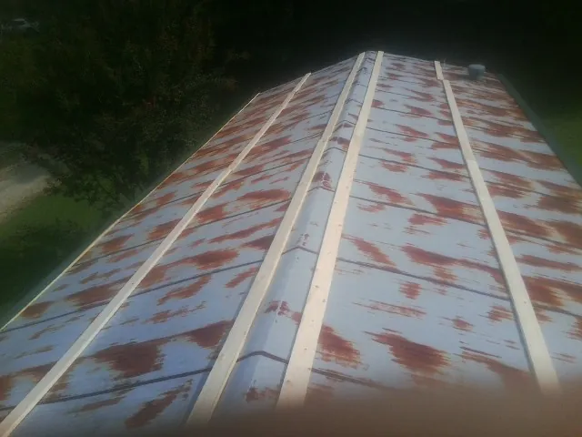 Rusted metal roof panels with new wood purlins before replacement — Storm Damage Roof Repair in Scammon by Roofing Brothers