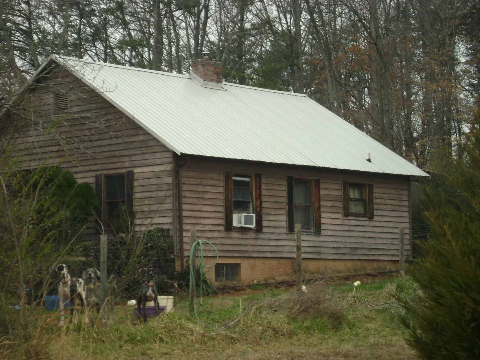 White metal roof on an old wood sided farmhouse, from a Metal Roof Installation job in Scammon